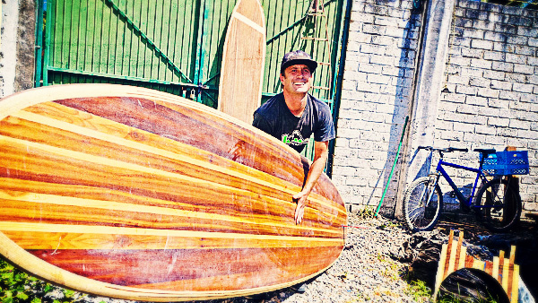 Andy Lambrecht with a handmade hollow core wooden stand-up paddleboard