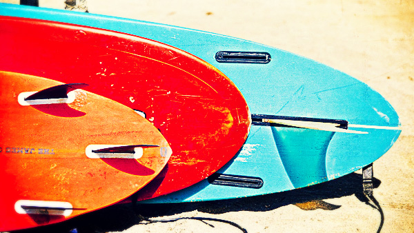 A selection of boards on the beach. Note the longboard’s two extra fin slots